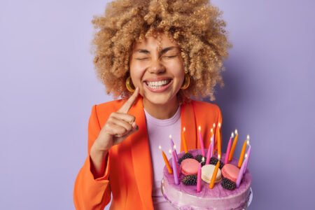 portrait of cheerful curly haired woman points mind