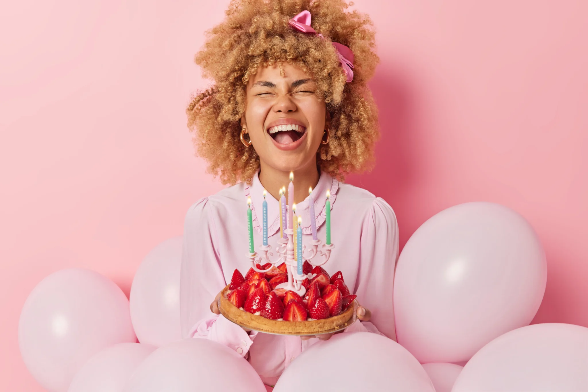 Horizontal shot of overjoyed curly haired woma
